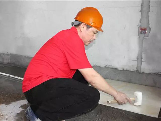 5鋪貼地磚時，磚的背面朝上批刮水泥油，并按箭頭所指方向統(tǒng)一鋪貼，用橡皮錘從中到邊，由重到輕敲實.jpg